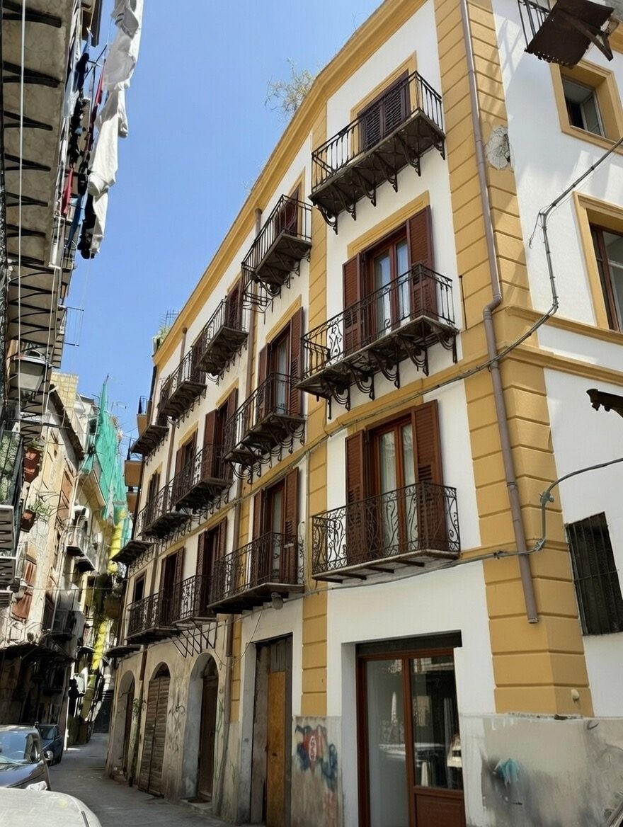 Rendering del prospetto ristrutturato su Via Coltellieri, facciata bianca con cornici ocra e balconi in ferro battuto