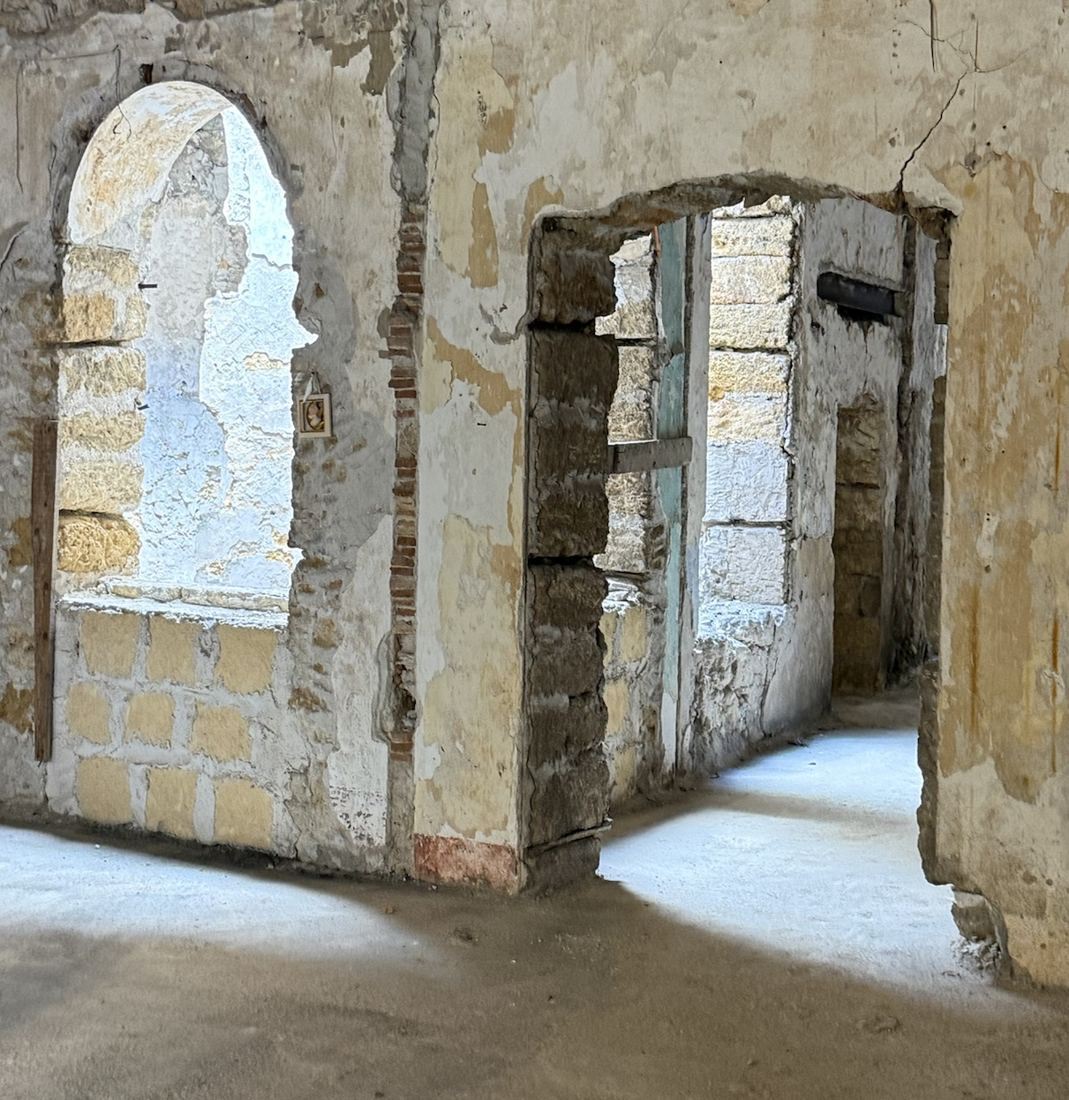 Arco in pietra e passaggio tra due ambienti, con murature in conci di tufo a vista
